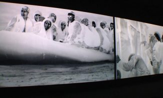 A grayscale image showing people in protective suits and face shields on an inflatable raft, likely engaged in a rescue or evacuation operation. Another panel shows individuals in similar attire engaged in an activity, possibly related to the event.